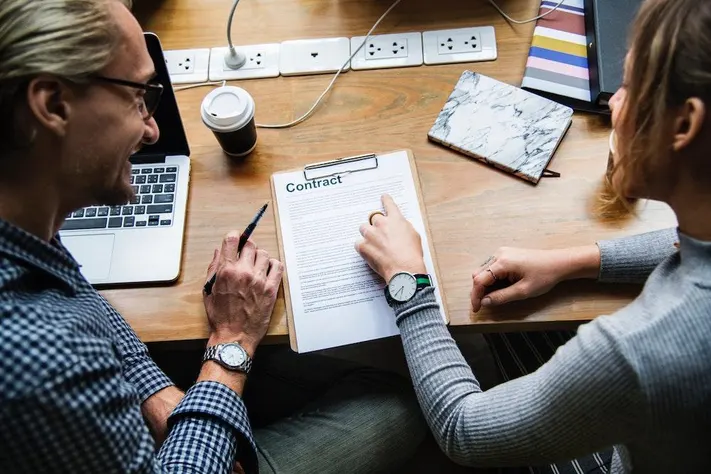 Two people discussing a contract